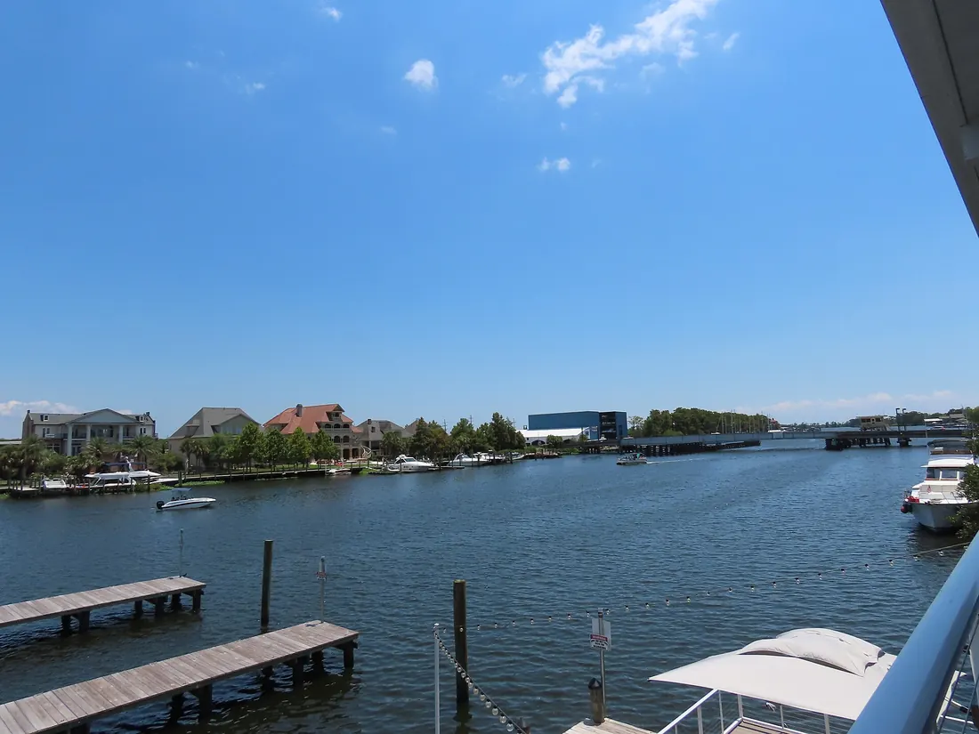Wide Tchefuncte River with wooden docks, boats, and waterfront homes under a clear blue sky