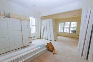 Unfinished commercial interior with stacked doors and drywall during a build-out