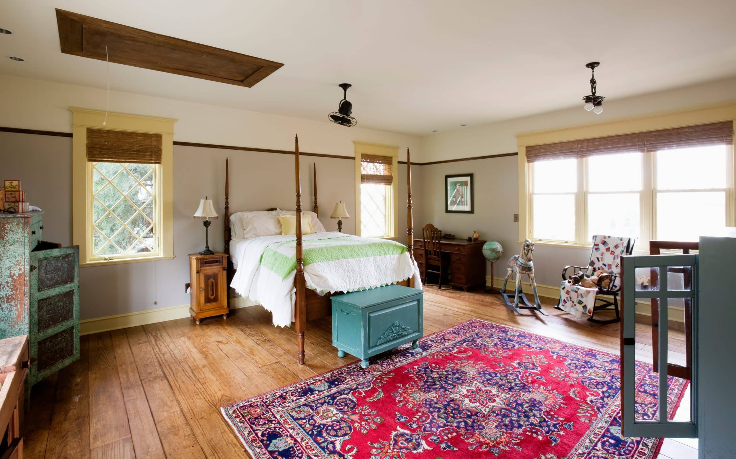 Bedroom in an older home with painted walls, wood trim and wide wood floors