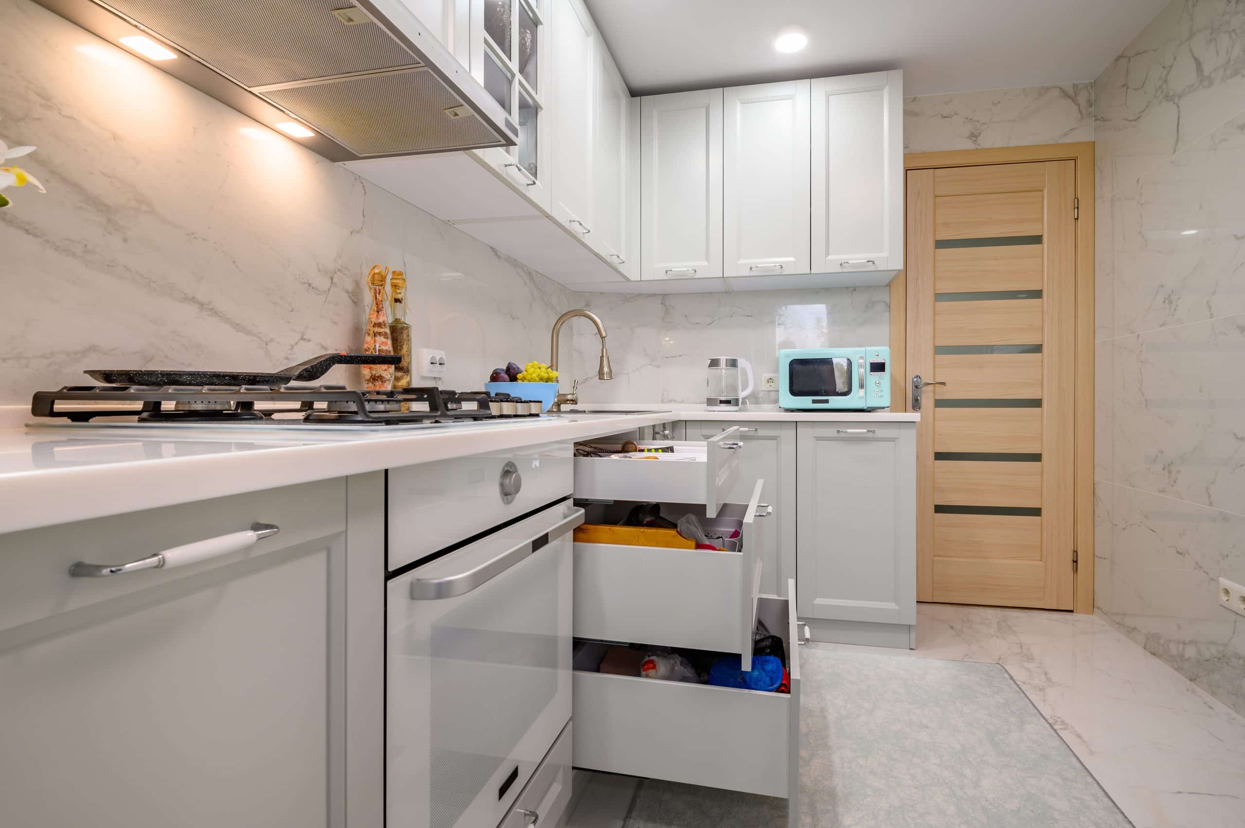 Gray kitchen cabinets with drawers pulled open
