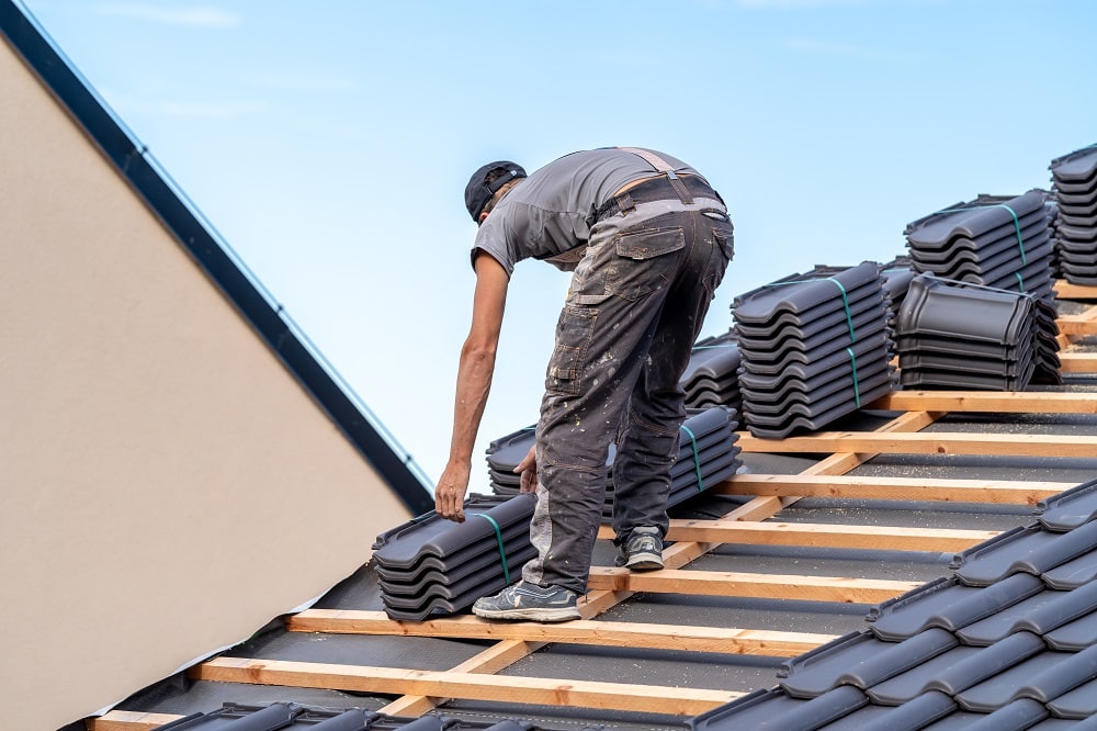 new roof of a family house, a roofer builds a roof made of ceramic tiles.