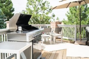 Covered outdoor patio kitchen with grill and dining area
