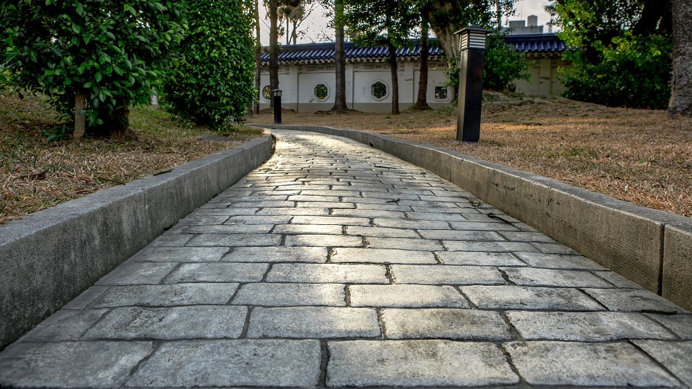 Paving stone road. Old pavement of square cobblestone sidewalk in Taipei. Garden patio in backyard stone brick pavers in Taiwan. Concrete paver block floor for background.