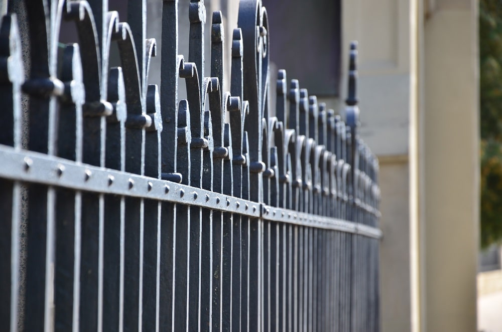 Close view of a decorative iron fence with repeated cast details