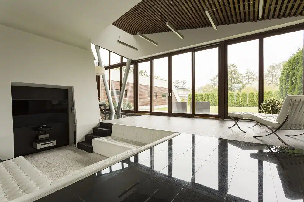 Bright villa interior with wood ceiling, black floor and tv