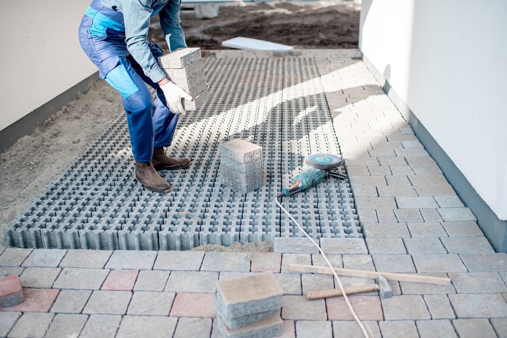 Builder carrying paving tiles on the construction site, cropped image with no face