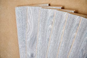 Wood-look plank flooring samples fanned out on a subfloor