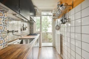 Narrow galley kitchen with tiled walls and wood countertop